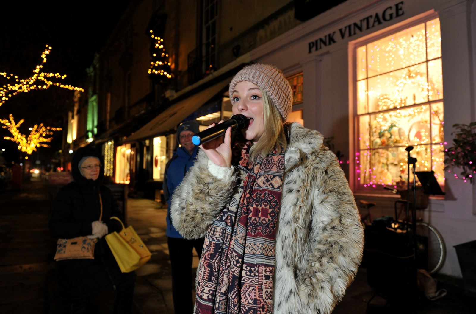 Singer singing into microphone at late night shopping event