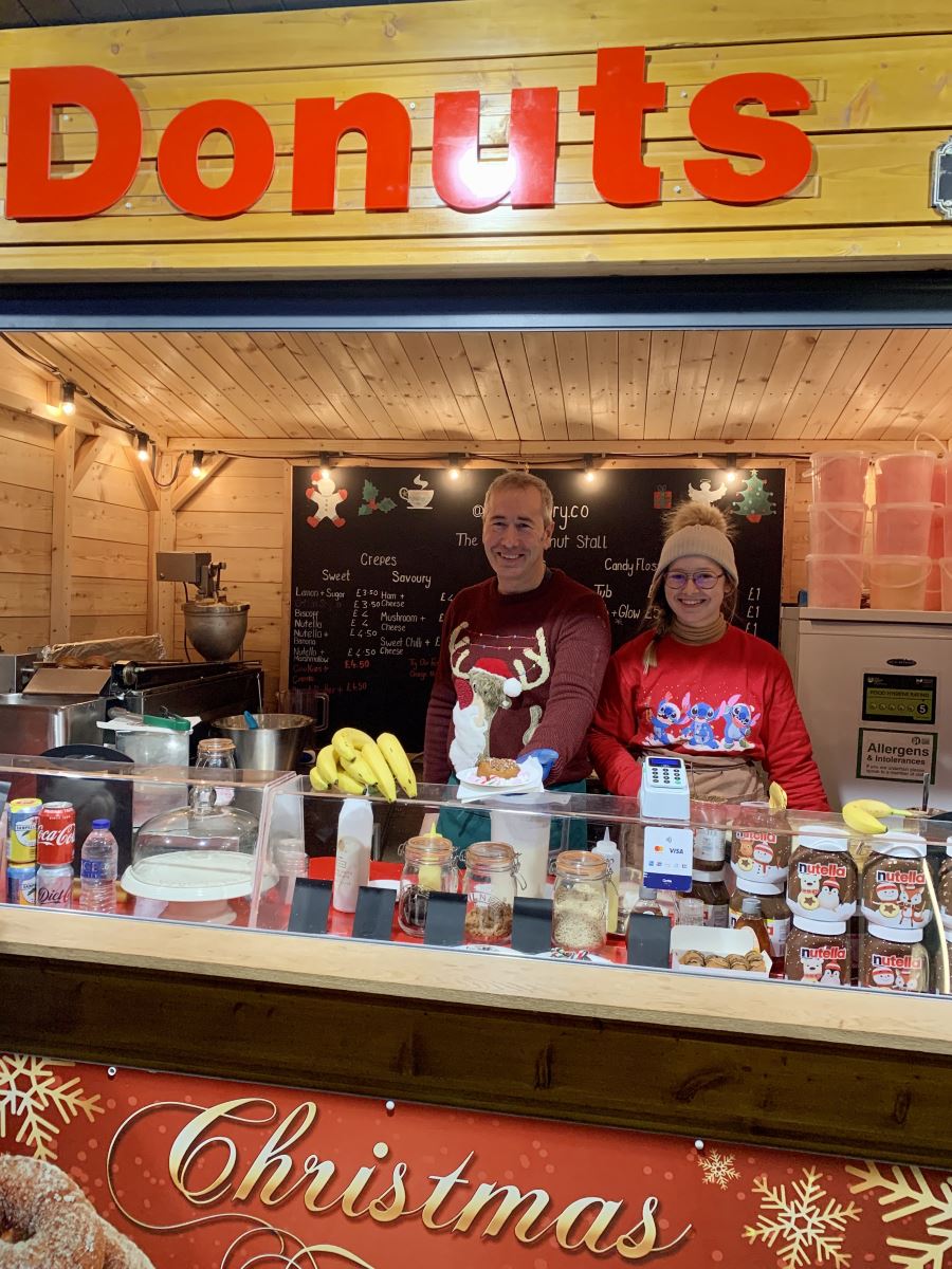 Man serving customers at donut stand