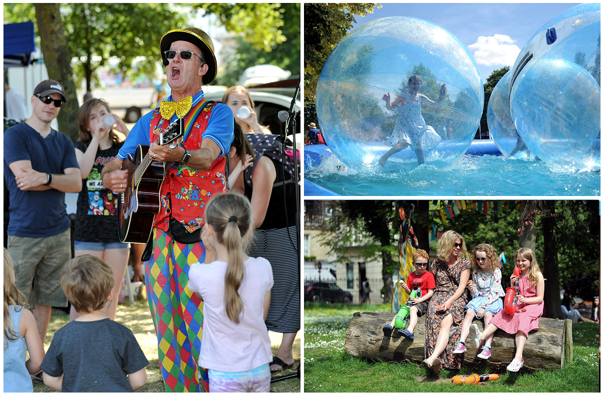 A childrens performer playing guitar, a young child in a blow up zorb ball, a mum and her kids relaxing in the sun. 