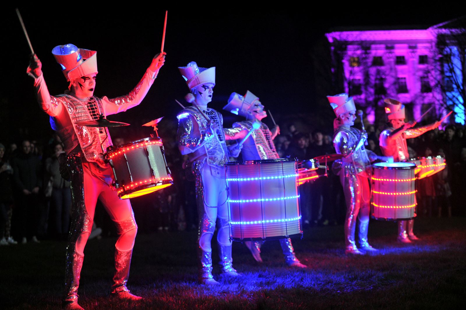 Spark! performers illuminated in different colours performing in Cheltenham
