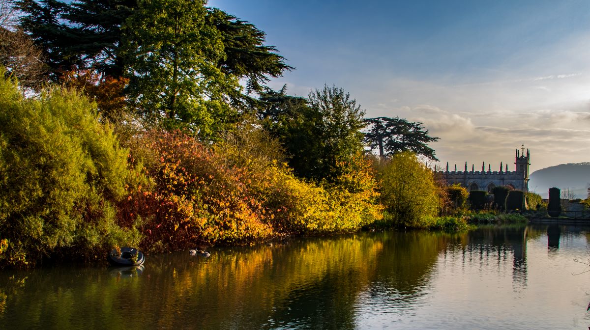 Castle grounds, shot across a lake towards castle walls during autumn
