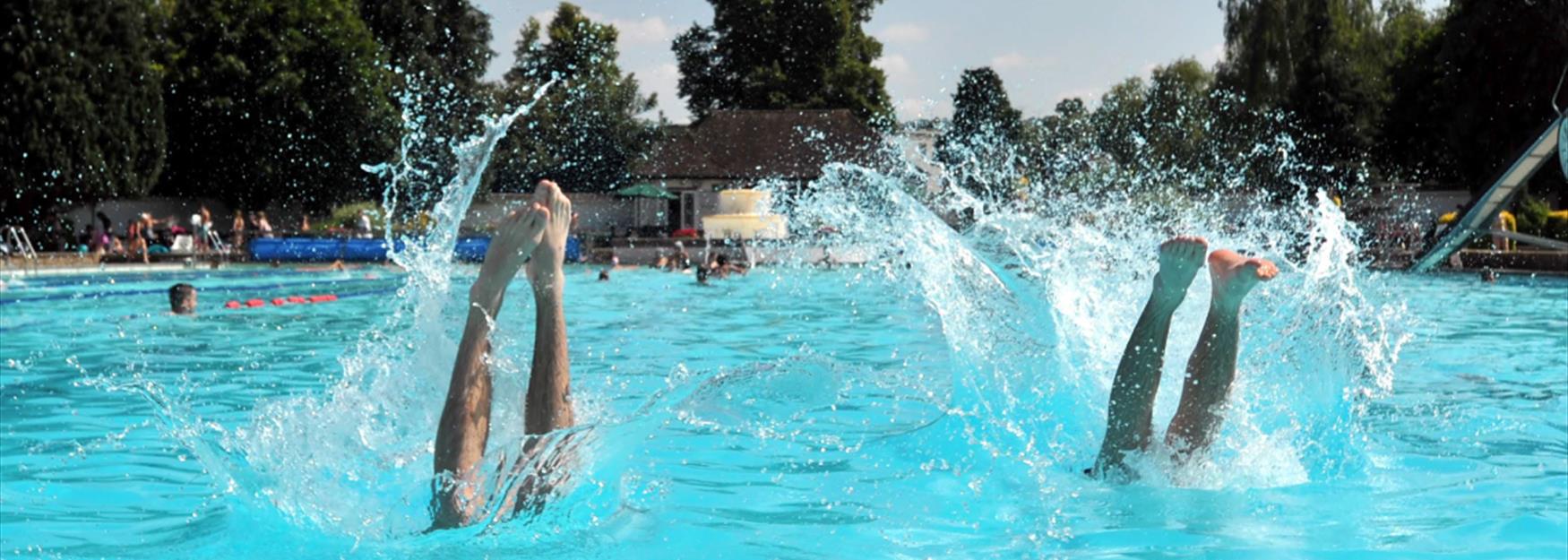 Two people dive into the outdoor pool at Sandford Park Lido in Cheltenham