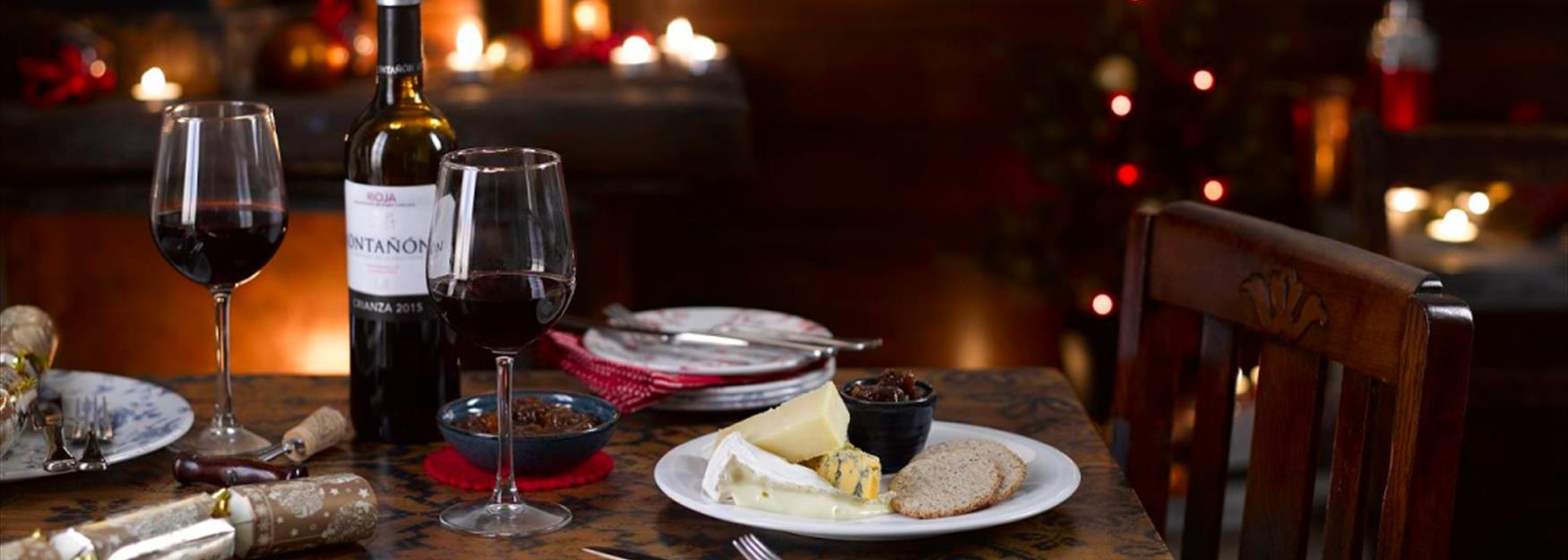 Table set for Christmas with cheese and red wine