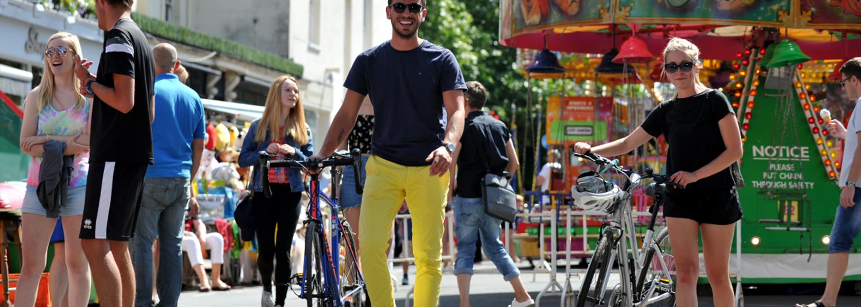 Young couple walking with the cycles through Cheltenham