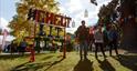 Group of people walking passed Cheltenham Lit Fest sign in Montpellier Gardens