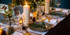 Set dining table with candles and Christmas decorations.