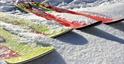 Close up of skis and snowboards in the snow